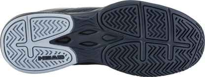 The image showcases the sole of the HEAD Revolt Court Women's Tennis Shoes, displaying a multi-patterned tread design. The lightweight comfort sole is primarily black with a gray section, featuring the "HEAD" brand name printed on it. The wavy, zigzag, and grid patterns provide traction, making these blueberry and light blue shoes ideal for agile performance.