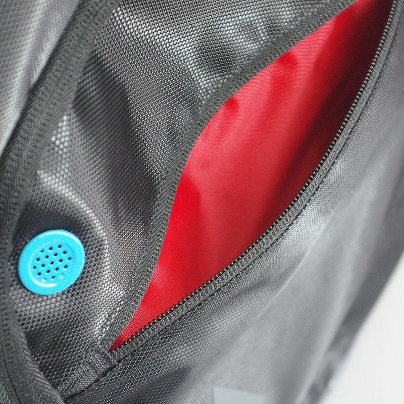 Here's a close-up of the Karakal Pro Tour 30 2.1 Tennis Backpack in black and blue. The bag features a textured exterior with an open zippered pocket lined with red fabric. On the left side, there is a round blue ventilation hole with small perforations. For maximum comfort, it comes with padded shoulder straps and offers a generous 30-litre capacity.