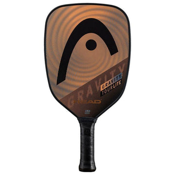 The HEAD Gravity Tour Lite 2023 Pickleball Paddle features a hybrid hitting surface, black grip, and a rounded rectangular face with a sleek black and copper design displaying the HEAD logo and “GRAVITY TOUR LITE.”.