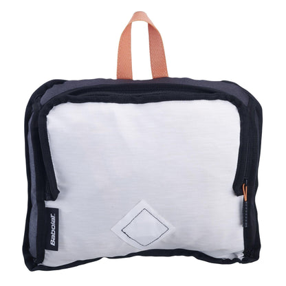 The Babolat Classic Backpack in beige features a black and white rectangular zippered pouch made from recycled materials, complete with a brand tag on the bottom left corner. The design includes an orange handle on top and a small diamond-shaped emblem on the front, reflecting the classic tennis backpack style.