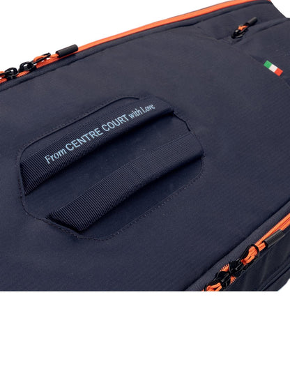 Close-up of the HEAD Pro 9 Racket Tennis Bag L in navy by HEAD, featuring orange zippers, a handle with "From CENTRE COURT with Love" text nearby, and a small Italian flag in the upper right corner.