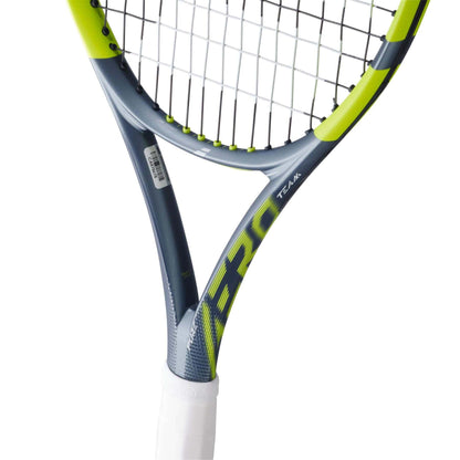 A close-up of the Babolat Pure Aero Team 2026 Tennis Racket with a grey and yellow aerodynamic frame, white grip, black strings, and "AERO" along with "TEAM" printed on the throat.