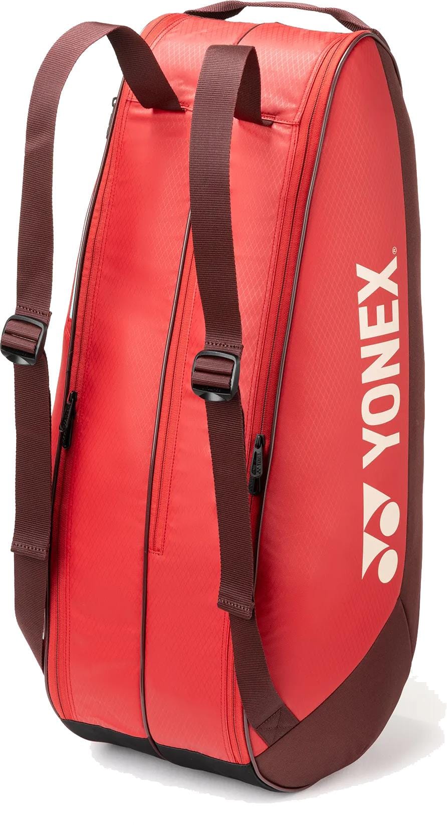 The Yonex 42526EX Team 6 Racket Tennis Bag in ruby red features brown adjustable shoulder straps, two zippered compartments, and a white Yonex logo—stylish and practical for everyday tennis play.