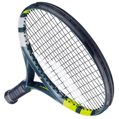 A close-up of the Babolat Aero Junior 26 Tennis Racket 2026 shows its modern design with a black grip, dark graphite composite frame, and white and yellow accents; the oval head features a grid of strings.