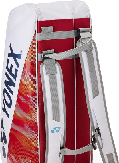 A close-up of the Yonex 02626EX Expert 6 Racket Tennis Bag in white, featuring red accents, gray padded shoulder straps, a flame-like orange design, and space for up to 6 rackets with thermoguard protection.