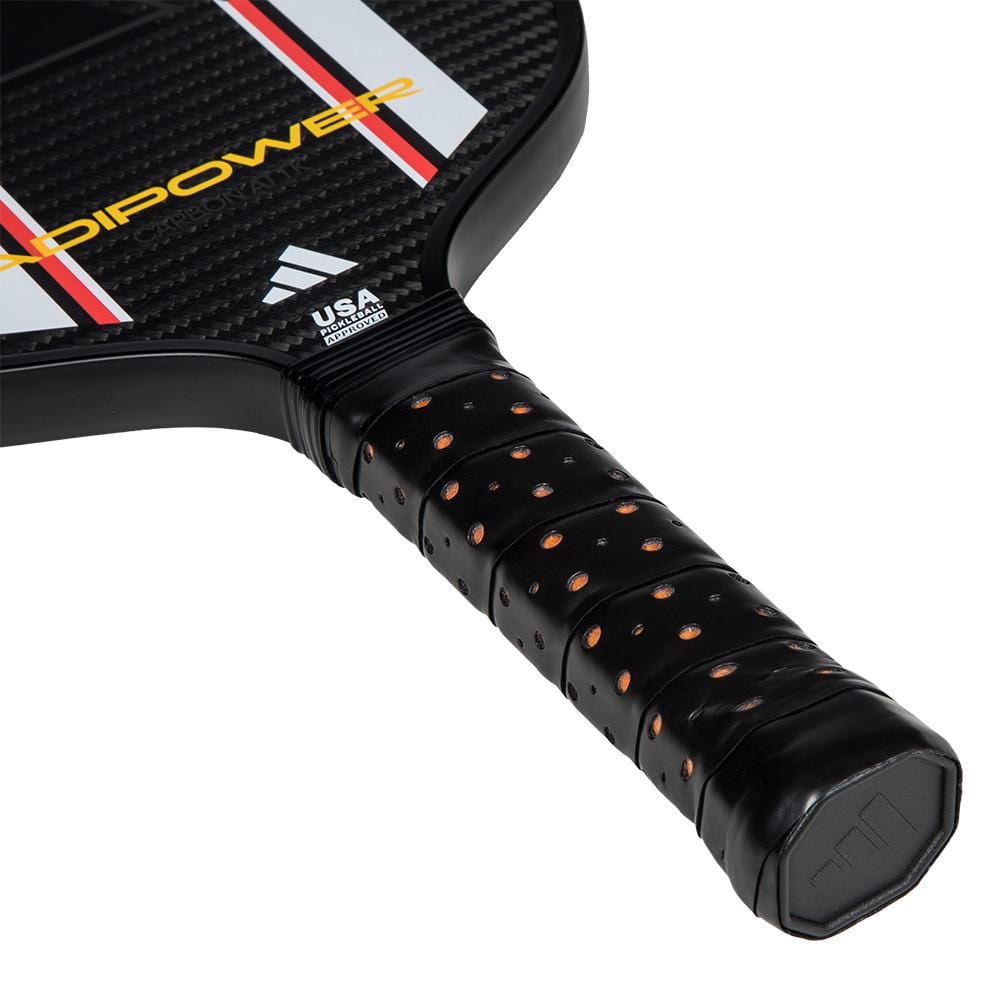 Close-up of the handle and face of the adidas ADIDAS Adipower Carbon ATTK 3.3 Pickleball Paddle in Black/White, showing its textured grip, red, white, and yellow accents, and USA Pickleball logo on the neck. Advanced-level design.