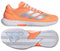The ADIDAS Defiant Speed 2 Womens Tennis Shoes in orange by adidas are shown from the side and sole, featuring silver stripes, a white midsole, and a patterned rubber outsole. Lightweight design offers comfort and speed for women on the court.