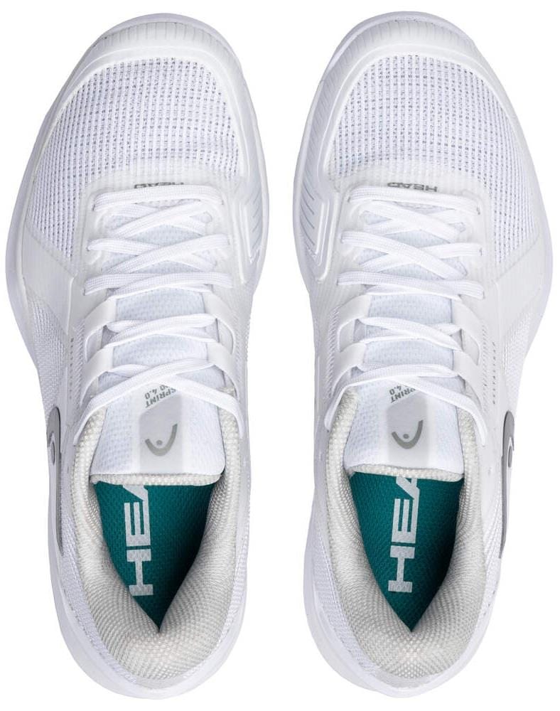 A pair of HEAD Sprint Pro 4.0 Womens Grass Court Tennis Shoes in white/grey with mesh uppers, white laces, and teal "HEAD" insoles are viewed from above; these sneakers are lightweight and breathable.