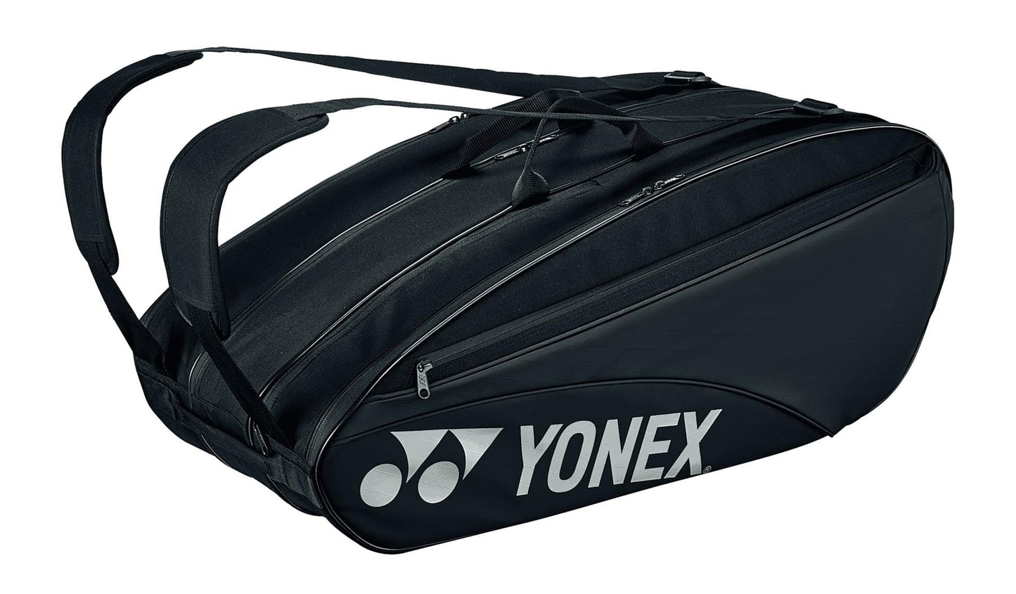 Introducing the Yonex 42329EX Team 9 Racket Tennis Bag - Black, a stylish and versatile carrier with two shoulder straps and a prominent Yonex logo on the side. This sleek bag includes multiple zippered compartments, featuring a dedicated shoe compartment for optimal organization of your gear.