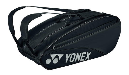 Introducing the Yonex 42329EX Team 9 Racket Tennis Bag - Black, a stylish and versatile carrier with two shoulder straps and a prominent Yonex logo on the side. This sleek bag includes multiple zippered compartments, featuring a dedicated shoe compartment for optimal organization of your gear.