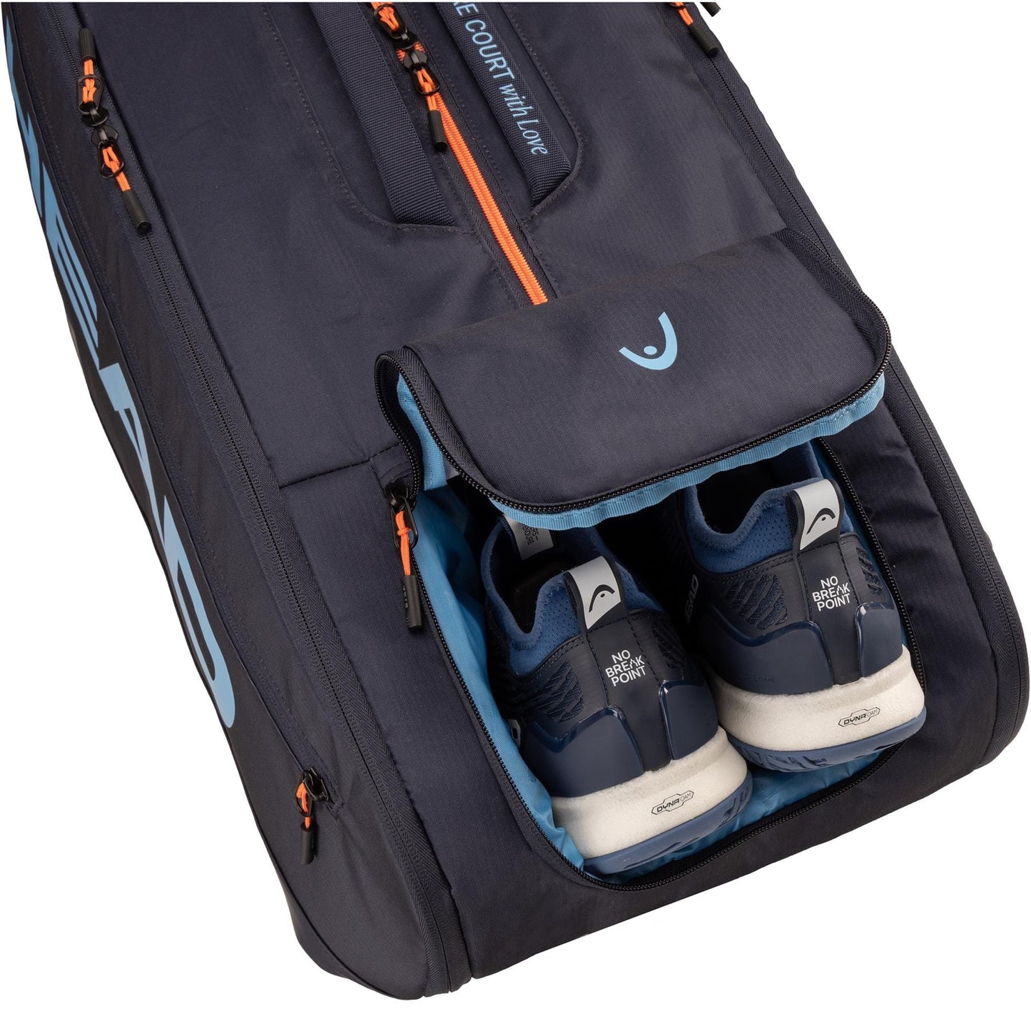 The HEAD Pro 12 Racket Tennis Bag XL - Navy by HEAD features orange zippers and light blue accents, with an open compartment displaying dark blue and white athletic shoes inside. Inspired by the Jannik Sinner tennis bag.