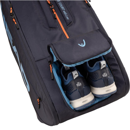 The HEAD Pro 12 Racket Tennis Bag XL - Navy by HEAD features orange zippers and light blue accents, with an open compartment displaying dark blue and white athletic shoes inside. Inspired by the Jannik Sinner tennis bag.