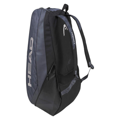 The HEAD Djokovic Monstercombi 12R Tennis Racket Bag in Anthracite and Black showcases "HEAD" in bold white lettering on the side. Inspired by Novak Djokovic, this bag includes multiple compartments, adjustable shoulder straps, and innovative CCT+ climate control technology to safeguard your gear.