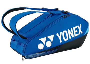 A Yonex 92426EX Pro 6 Racket Tennis Bag in cobalt blue, featuring the Yonex logo in white. It includes multiple zippered compartments and adjustable black straps, perfect for carrying sports equipment. The tennis bag is displayed against a plain white background.