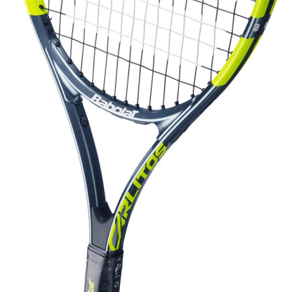 Close-up of the Babolat Carlitos Junior 25 Tennis Racket by Babolat, featuring a black and neon yellow frame with visible strings and handle. The brand name and model details appear on the frame, making it ideal for junior players.