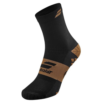 A close-up of a single Babolat Pro Crew Men's athletic sock, perfect for sports players, showcases a black and bright gold color scheme. This technical sock features a unique geometric design with Babolat branding near the ankle and foot. The ankle height and textured fabric are designed to enhance performance and comfort for racket sports.