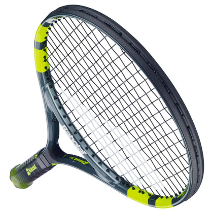 A close-up angled view of the Babolat Carlitos Junior 26 Tennis Racket by Babolat, featuring a black and yellow design with visible strings and part of the handle—perfect for beginner junior players.