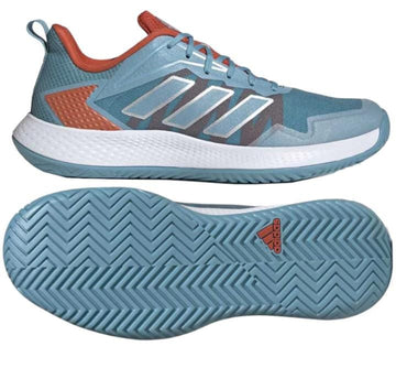 These adidas Defiant Speed Women's Tennis Shoes in blue boast a lightweight mesh upper and showcase vibrant orange accents paired with white soles. The geometric pattern and herringbone tread enhance both style and functionality, while the iconic adidas logo is prominently displayed on the sole.