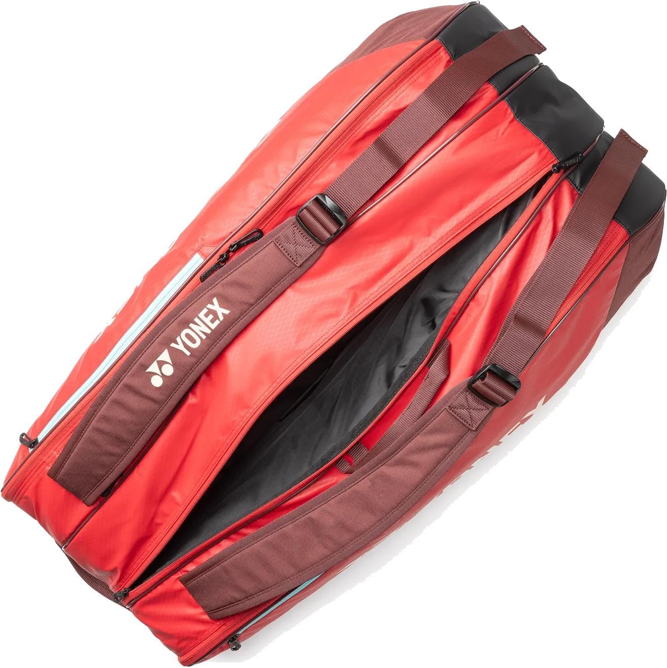 The Yonex 42529EX Team 9 Racket Tennis Bag in Ruby Red offers ample space for up to nine rackets, featuring brown straps and zippers, a spacious interior, and the trusted Yonex brand—ideal for players needing plenty of storage.