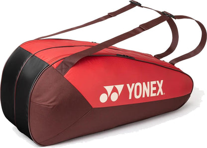 The Yonex 42526EX Team 6 Racket Tennis Bag in Ruby Red features two shoulder straps and the Yonex logo in white, offering spacious storage for rackets and sports gear.
