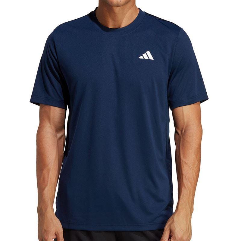 A person wearing a navy ADIDAS Men's Club Tennis T-Shirt featuring a small white logo on the left chest. The AEROREADY fabric provides comfort, while the plain white background accentuates the sleek design.