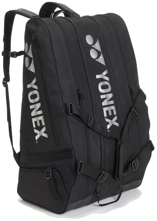 The Yonex BA726212EX Gearlogic 12 Racket Tennis Bag in black has three zippered compartments, sturdy shoulder straps, and a white Yonex logo—ideal for carrying sports gear or as a compact tennis bag.