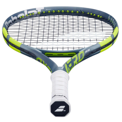 A close-up of the Babolat Pure Aero Junior 26 Tennis Racket 2026 shows its white grip, dark gray and neon yellow frame, black strings, and innovative spin technology, photographed from the handle end.
