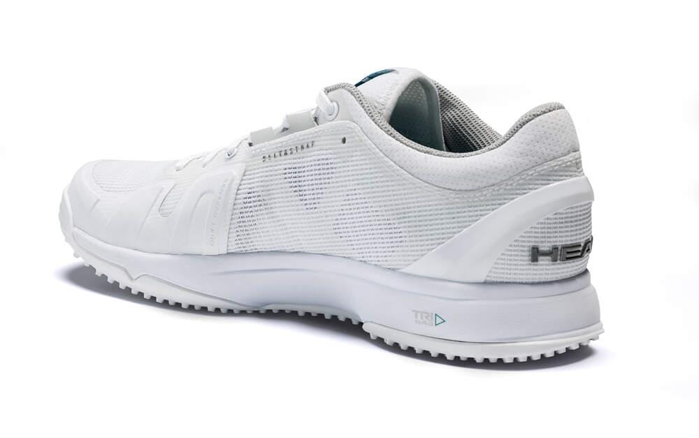 The HEAD Sprint Pro 3.0 Men's Grass Court Tennis Shoes in white and grey feature a textured upper with a subtle glimpse of the brand name on the heel. Highlighting Hybrasion+ Technology, the shoe's sole displays a distinct serrated pattern, and it is positioned to reveal both the side and back angles.