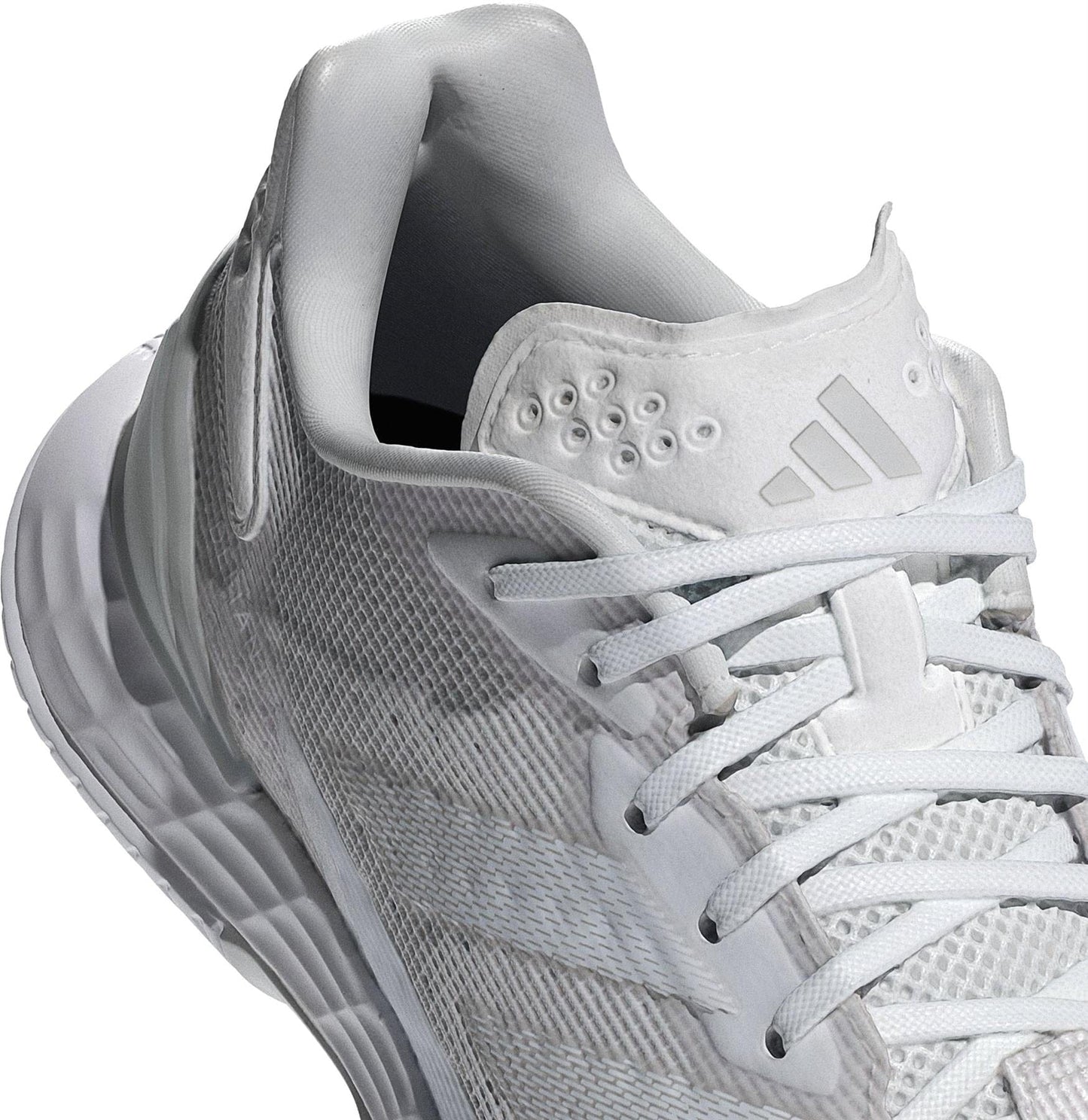 A close-up of the adidas Defiant Speed 2 Women's Tennis Shoes in white, featuring mesh details, white laces, a logo on the tongue, textured sole, and padded collar for comfort. Lightweight design ideal for tennis.