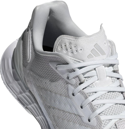 A close-up of the adidas Defiant Speed 2 Women's Tennis Shoes in white, featuring mesh details, white laces, a logo on the tongue, textured sole, and padded collar for comfort. Lightweight design ideal for tennis.