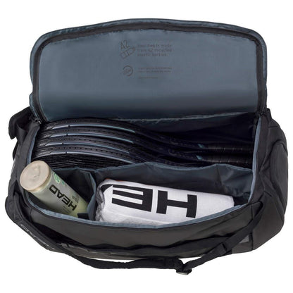 The open HEAD Pro X Tennis Duffle Bag L - Black from the renowned brand HEAD houses several tennis rackets, a white towel, and a bottle. Its inside lid proudly declares that it's made from recycled PET bottles and is equipped with CCT+ climate control technology to safeguard your gear.