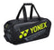 The Yonex 02331EX 2024 Expert Tournament Tennis Racket Bag in black and yellow merges luxurious design with functionality. This tennis racket bag features multiple compartments, including a dedicated shoe compartment, and is equipped with durable black handles for effortless carrying.