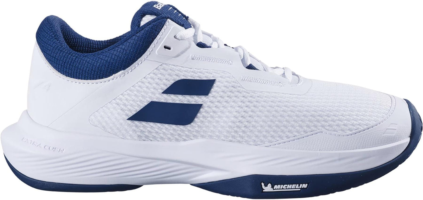 The Babolat SFX 4 All Court Men's Tennis Shoes in White/Estate Blue feature a white mesh upper with navy accents, a dark blue logo, and "Michelin" on the outer sole near the heel for added comfort and style.