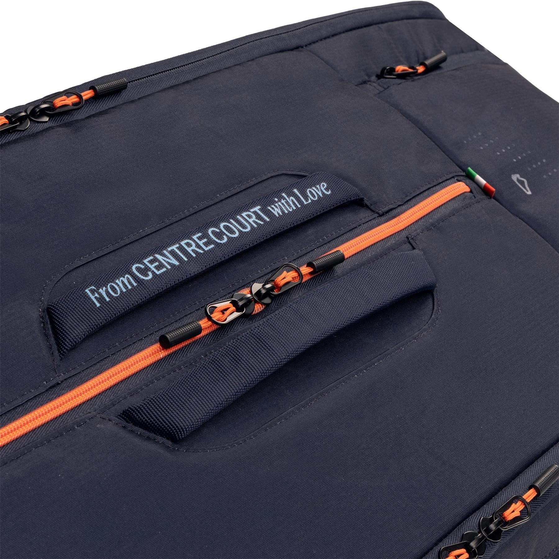 Close-up of the HEAD Pro 12 Racket Tennis Bag XL - Navy by HEAD, featuring orange zippers, black pulls, and a stitched “From CENTRE COURT with Love” label in white—design inspired by Jannik Sinner’s tennis bag.