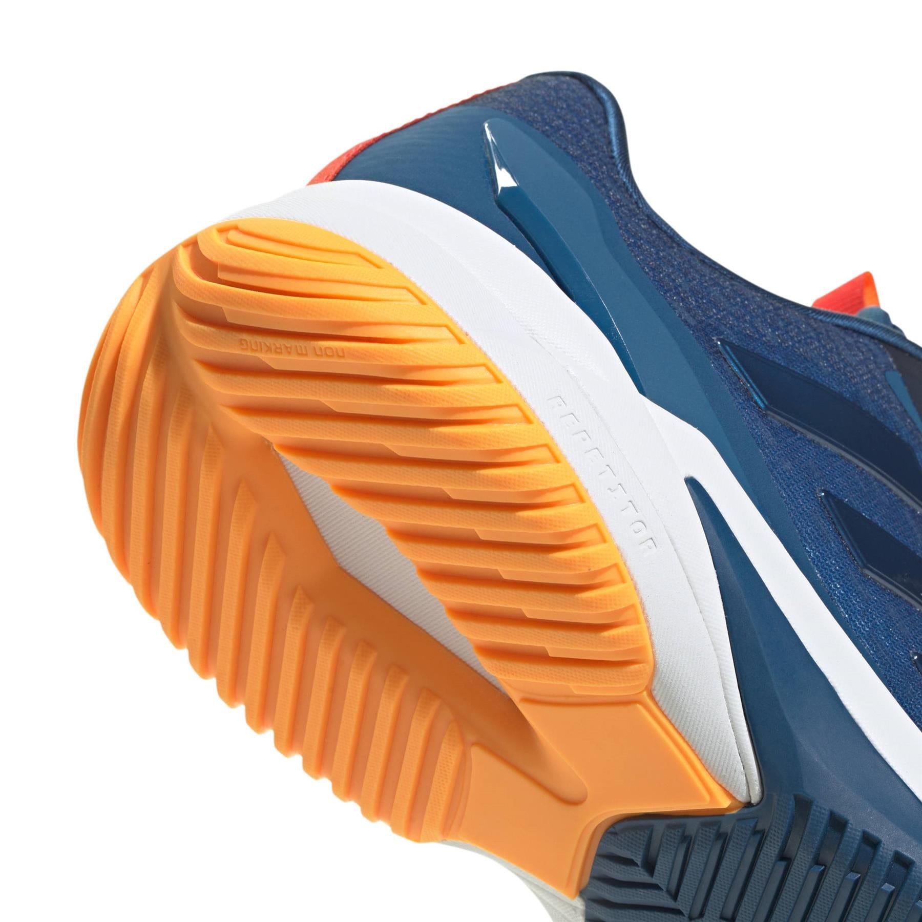 Close-up of the sole on the navy adidas Crazyflight 6 Men’s Indoor Tennis Shoes, featuring orange and white tread details that highlight the shoe’s textured grip and design.