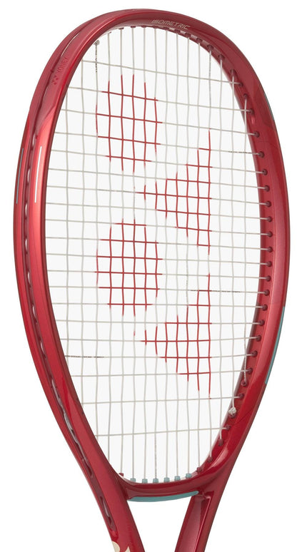 The Yonex VCORE 100D Ruby Red 2026 tennis racket features white strings with a red Yonex logo at the center, delivering great spin potential. It is shown against a white background.