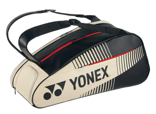 The Yonex 82426EX Active 6 Racket Tennis Bag in Black and Beige boasts red zippers and the renowned Yonex logo. This elegant tennis bag includes two shoulder straps and a contemporary design, making it ideal for athletes on the move.