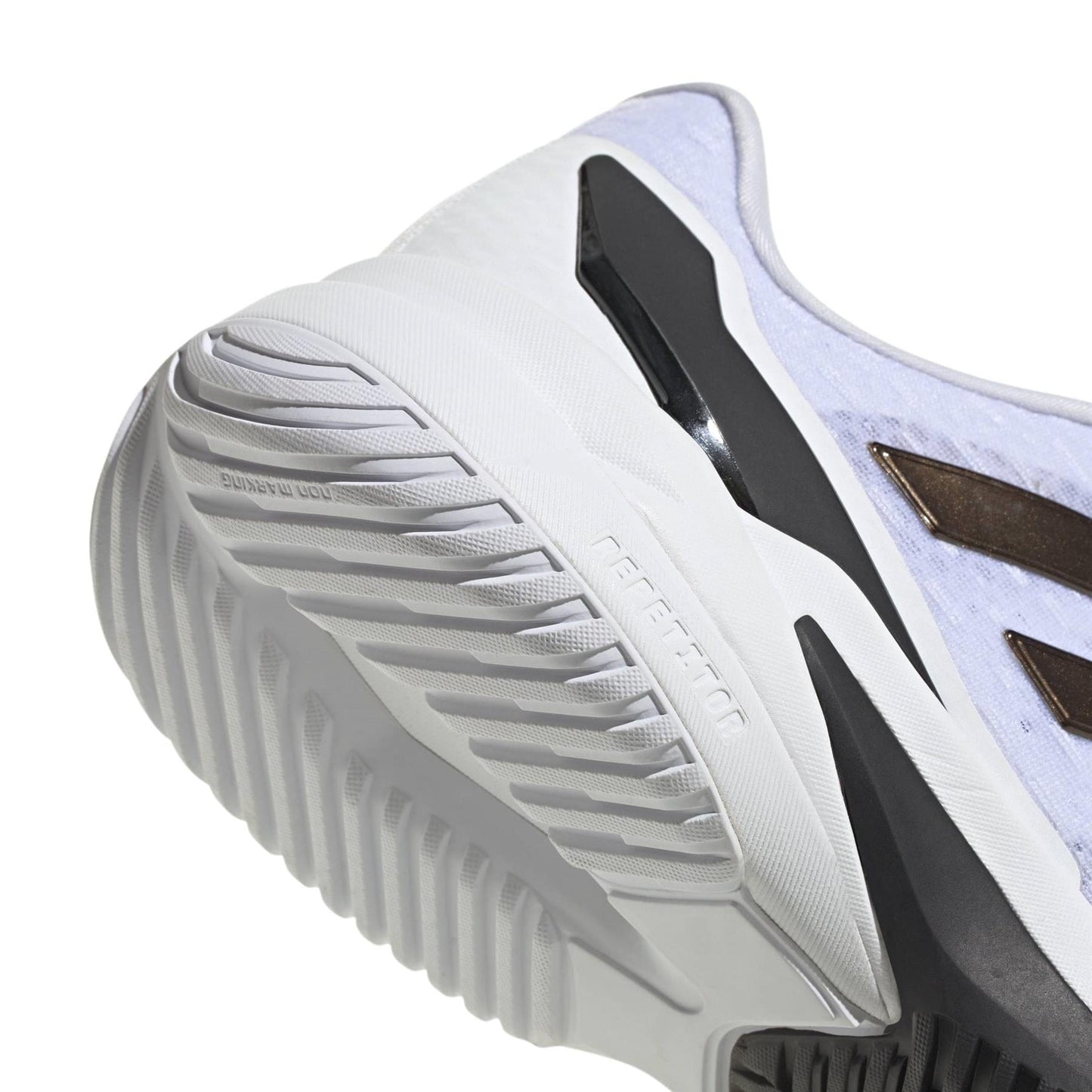 Close-up of the sole and side of a white adidas Crazyflight 6 Men's Indoor Tennis Shoe, showing its textured grip, black accent, gold stripe detail, tread pattern, and upper material.