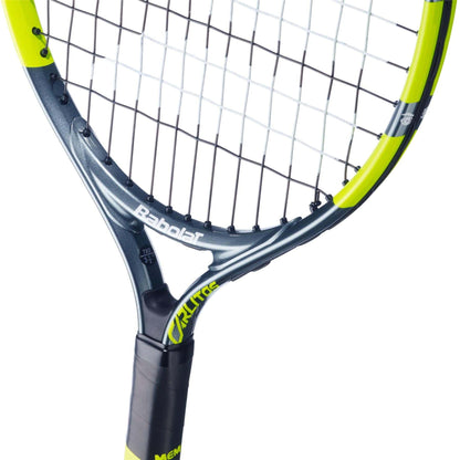 Close-up of the Babolat Carlitos Junior 19 Tennis Racket for kids, featuring a black and yellow frame with visible strings and handle. The Babolat brand name appears on the junior racket's frame.