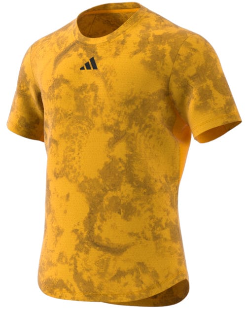 The ADIDAS Paris Men's Freelift Tennis T-Shirt in Gold/Yellow features a striking yellow pattern with a small chest logo, paired with a round neckline and short sleeves. Engineered for performance, its HEAT.RDY technology keeps you cool and comfortable.