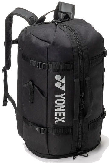 The Yonex BA72612EX Gearlogic Tennis Backpack in black features backpack straps, side handles, a vertical white Yonex logo, cylindrical shape, 40L capacity, and multiple zipper compartments for organized gear storage.