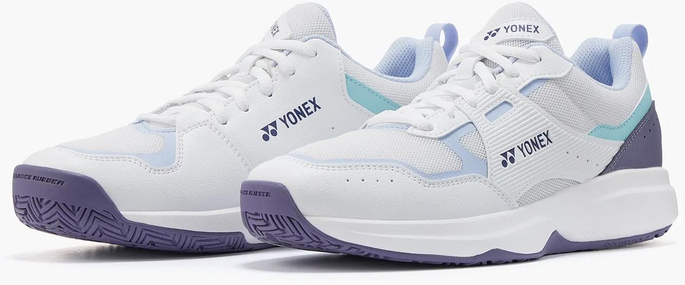 The Yonex Pro-Move Classic Mens Tennis Shoes in White/Sax feature mesh panels, light blue and purple accents, Power Cushion technology, and thick rubber soles—displayed side by side on a white background.