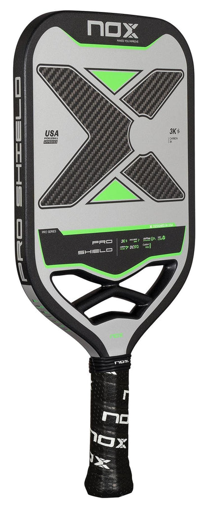 The NOX NOV Pro Shield Pickleball Paddle in black and green features a carbon fiber X pattern, Spin Technology, a perforated NOX-branded handle, and detailed specs printed on its face.