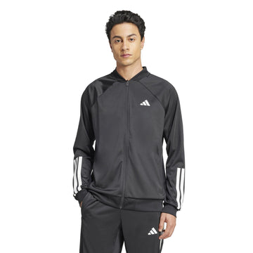 A person with short dark hair stands against a white background wearing an adidas Men's 3 Stripe Knit Tennis Jacket in black, featuring the iconic logo on the chest.