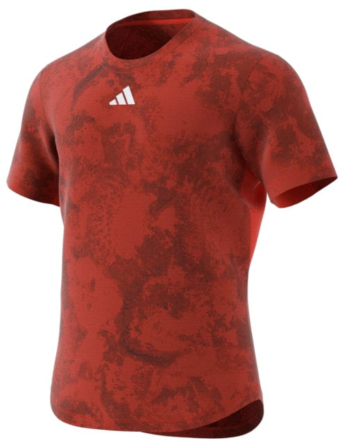 The ADIDAS Paris Men's Freelift Tennis T-Shirt in red, by adidas, boasts a small white triangular logo, short sleeves, and a round neckline. It is ideal for hot weather thanks to its HEAT.RDY technology that helps keep you cool.