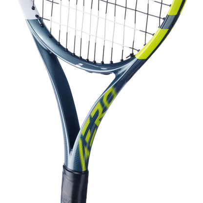 Close-up of the Babolat Aero Junior 25 Tennis Racket 2026 by Babolat, showing a dark teal graphite composite frame with yellow accents and black-and-white strings. "AERO" in yellow is visible on the racket head.