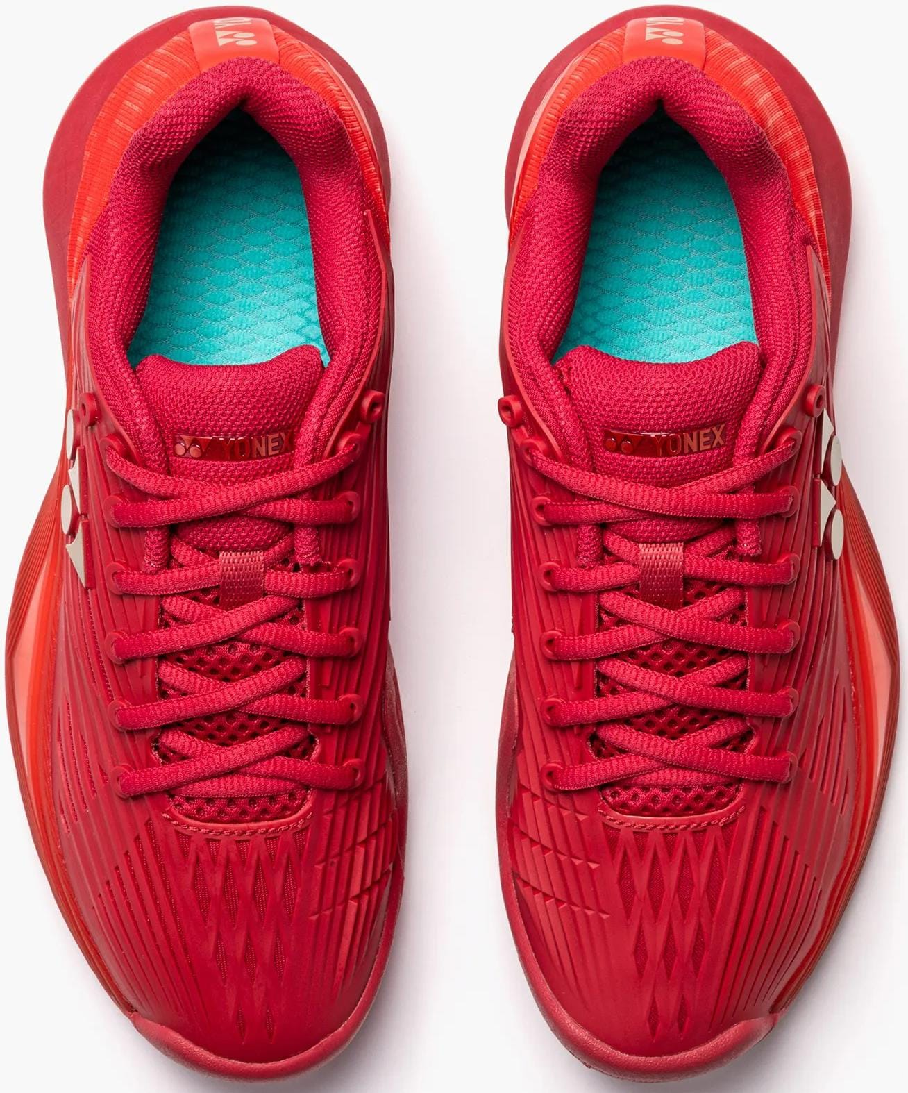 A pair of Yonex Power Cushion Eclipsion 5 Women's Tennis Shoes in Ruby Red, viewed from above. They feature red laces, turquoise inner soles, textured details, and Yonex Power Cushion logos on the tongues and sides.