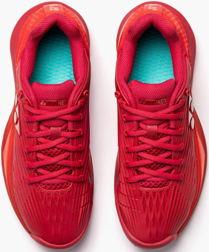A pair of Yonex Power Cushion Eclipsion 5 Women's Tennis Shoes in Ruby Red, viewed from above. They feature red laces, turquoise inner soles, textured details, and Yonex Power Cushion logos on the tongues and sides.