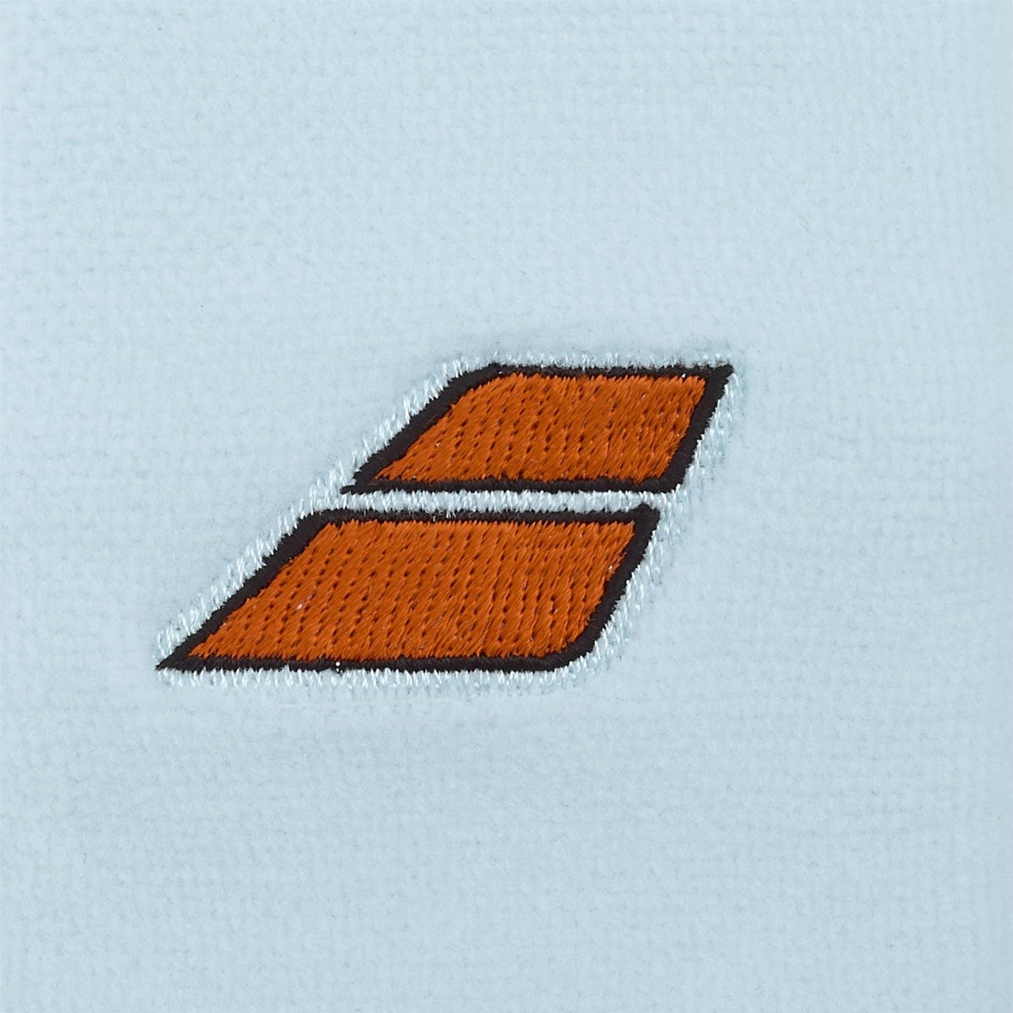 Two orange parallelograms with black outlines are stacked diagonally on a light blue textured fabric, evoking the absorbent comfort of the Babolat Terry Jumbo Wristband - Illusion Blue by Babolat.
