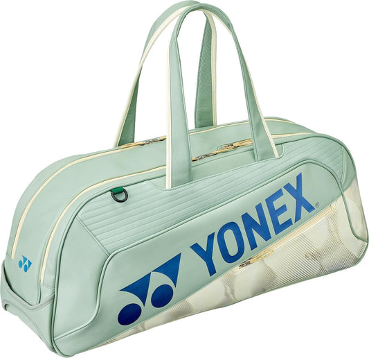 The Yonex 02631WEX Expert Tournament Tennis Bag in Smoke Green features cream zippers, a large blue Yonex logo with shuttlecock graphic, two top handles, a spacious structured design, and a separate shoe compartment.